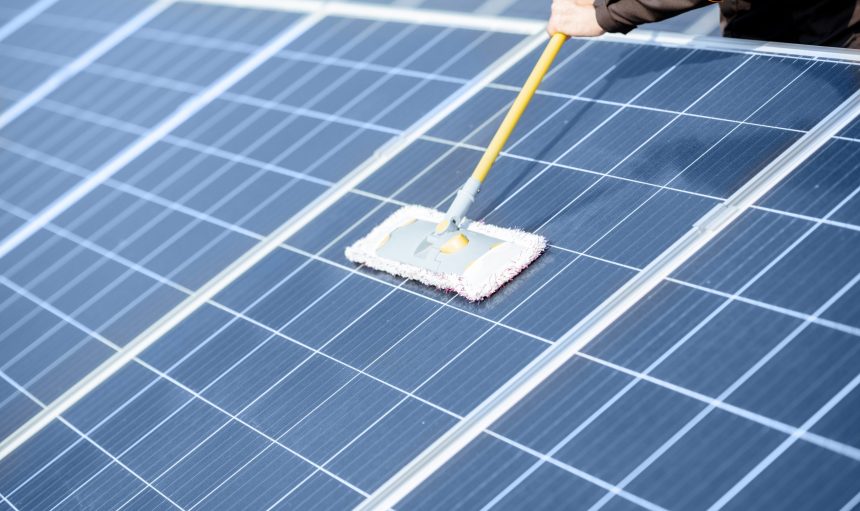 Close-up of professional cleaning of solar panels with a mob. Concept of solar power plant cleaning service